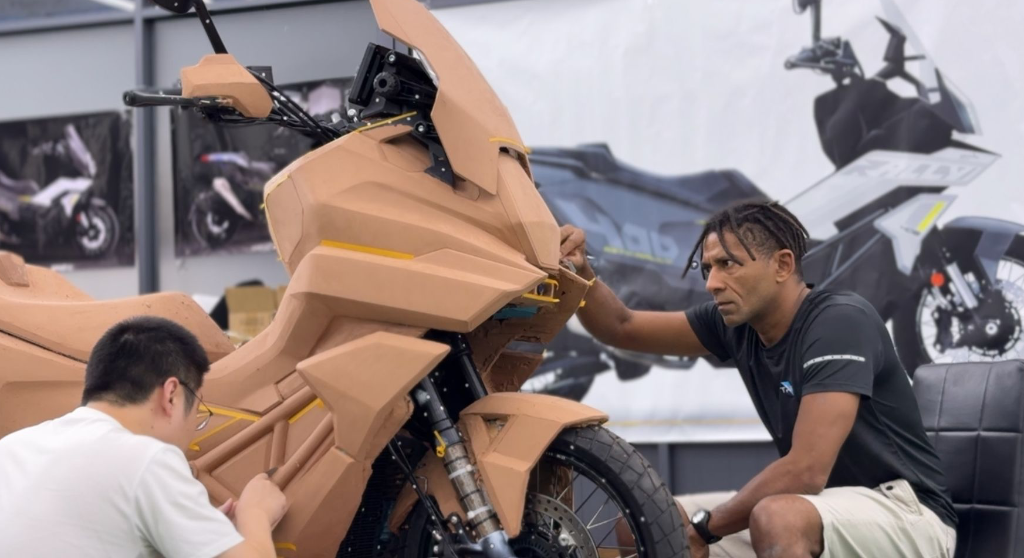Yacouba Galle working hands-on on a full-scale clay model, shaping the vehicle’s surfaces with instinctive precision. A rare behind-the-scenes moment showing the sculptural approach that defines his design process